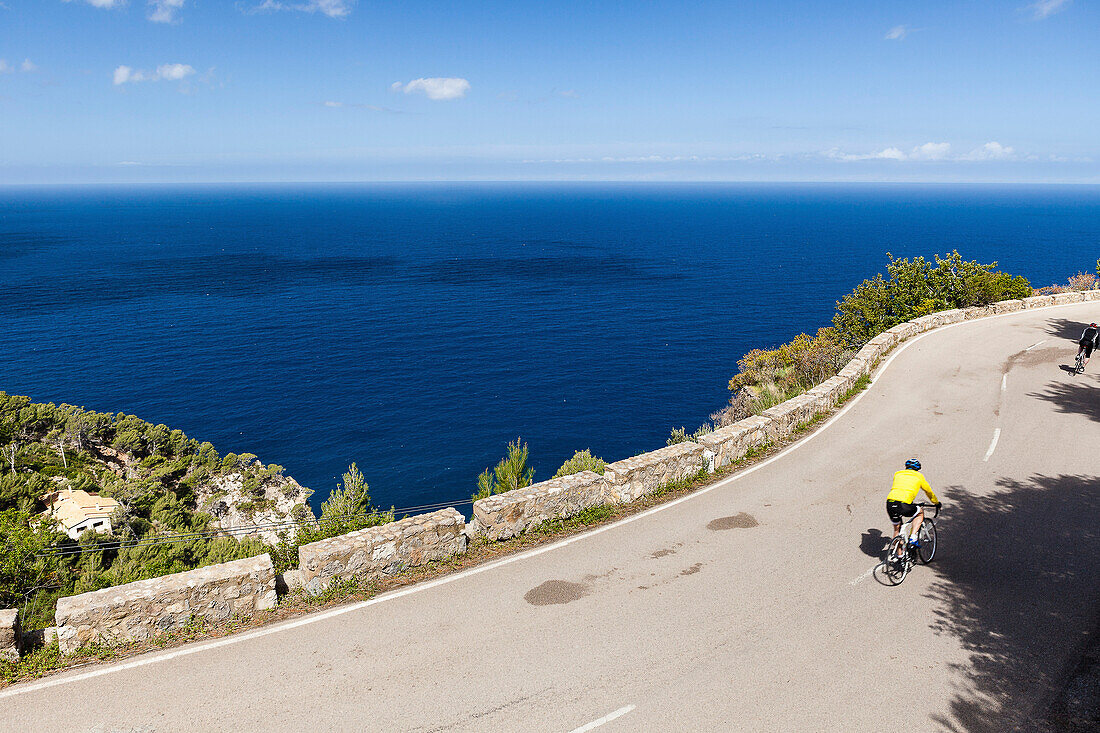 Bike racers on coast road overlooking Mediterranean Sea, Banyalbufar, Mallorca, Spain