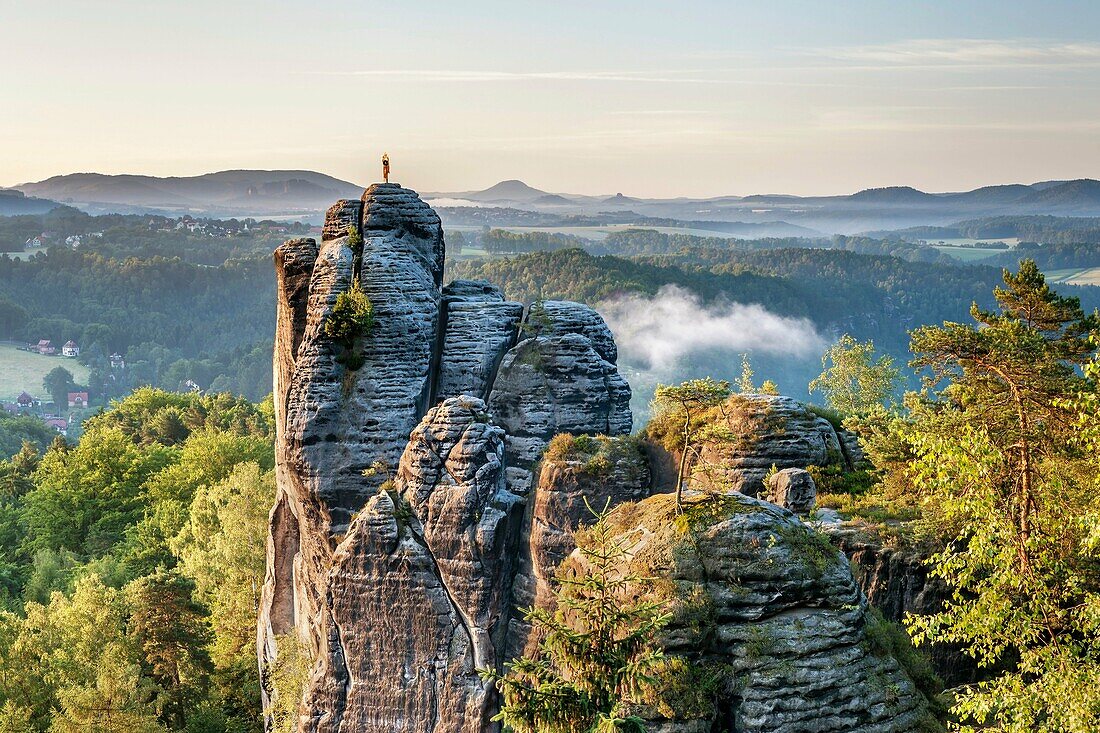 View to the rock Moench also Moenchstein monk or monkstone The Moench is a popular climbing tower rock in the National Park Saxon Switzerland near the health resort Rathen in the Elbe Sandstone Mountains At the top is a weather vane in the form of a monk,