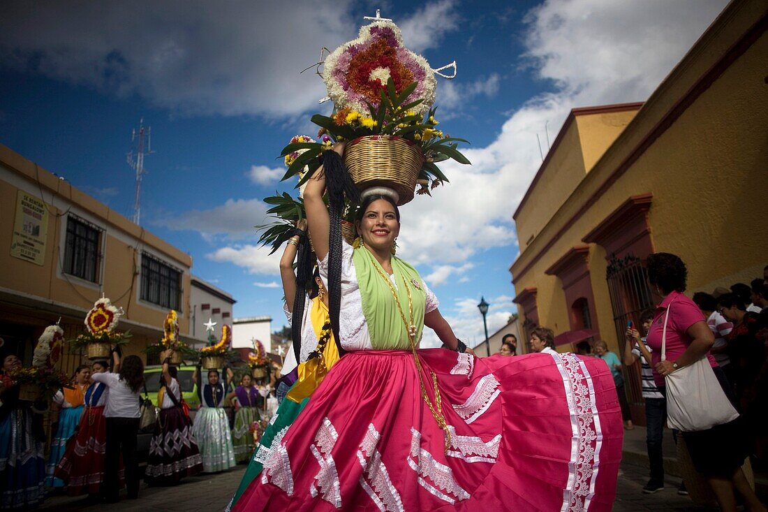 A ´china oaxaquena´ dances balancing a basket of flowers on her head in during the Guelaguetza parade in Oaxaca, Mexico, July 21, 2012  Oaxaca commemorates the ´Guelaguetza,´ an annual celebration by all seven of the state´s regions, as they converge on t