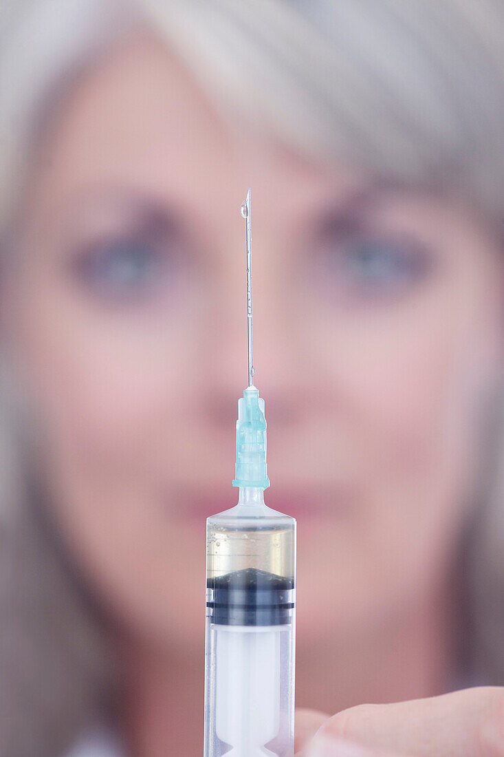 Lab. Scientist squeezing drop out of syringe