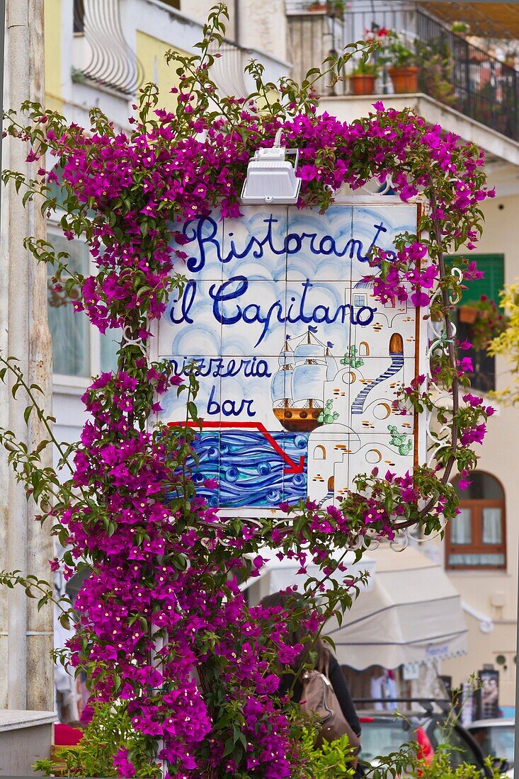 A restaurant sign with bougainvillea flowers in Positano, Amalfi Coast, Italy