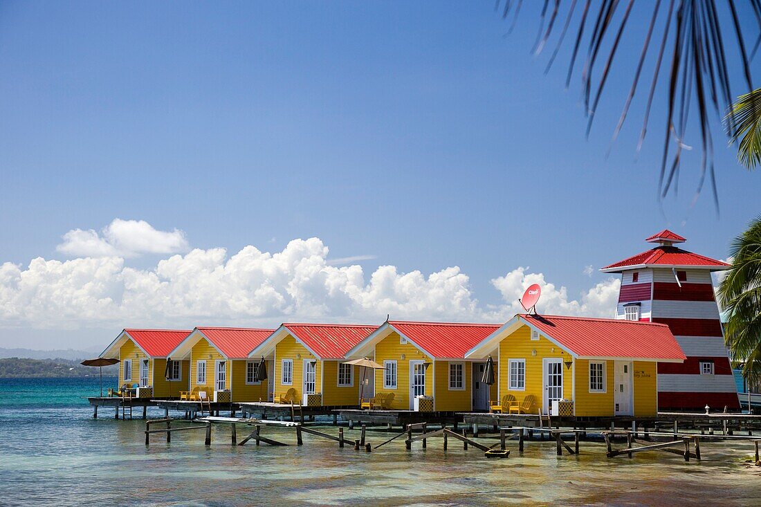 Yellow waterfront cabins at El Faro del Colibri hotel on Isla Carenero, Bocas del Toro Archipelago, Panama