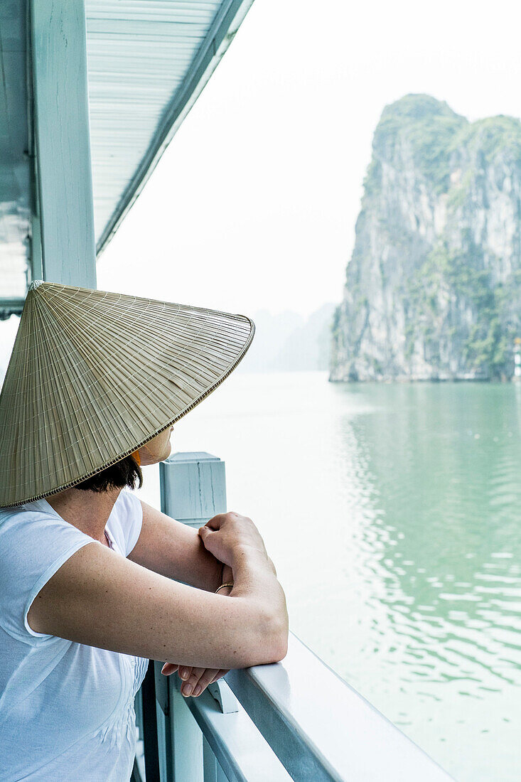 Woman on a wooden junk, enjoying the view in Halong Bay, north of Vietnam, Asia