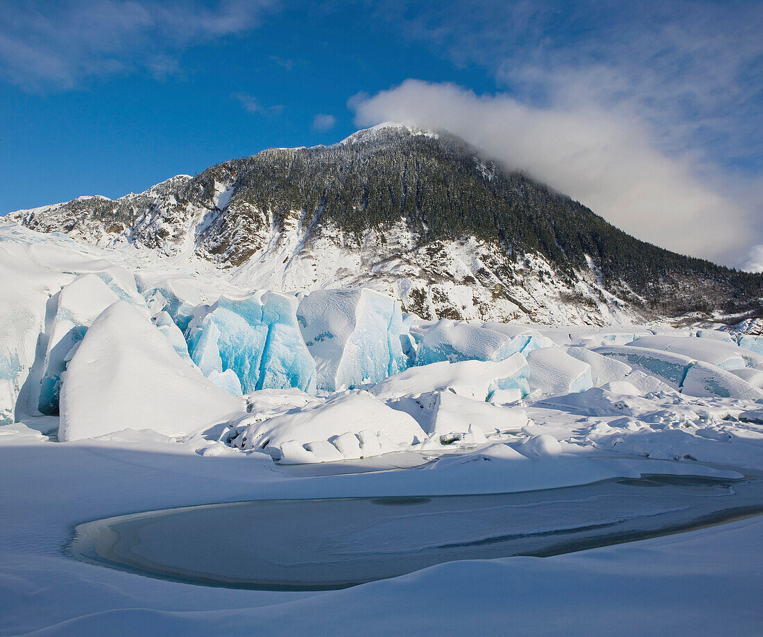 COMPOSITE Blanketed in new snow the face of Mendenhall Glacier rises from the frozen surface of Mendenhall Lake, Tongass Forest, Alaska.