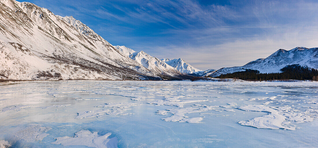 View of sastrugi wind carved ridges in the snow covering frozen Phelan Creek alongside the Richardson Highway as it heads into the Alaska Range, Southcentral Alaska, Winter