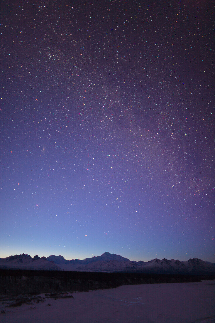 Night time view of Mt. McKinley with a star filled sky, the Milky Way, and a shooting star overhead, Denali State Park, Southcentral Alaska, Winter