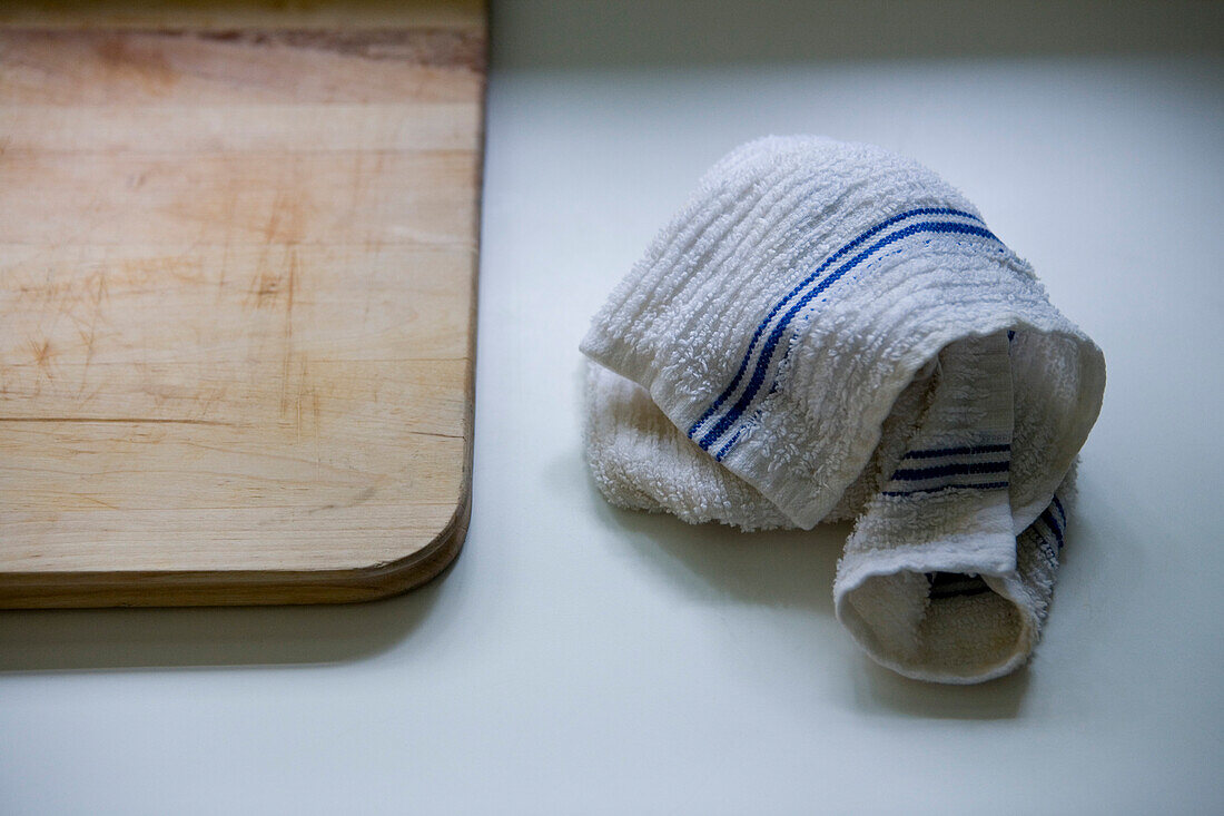Dish Towel on Counter Next to Wood Cutting Board