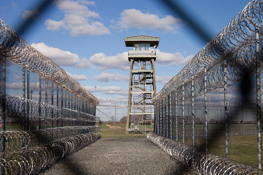 Prison fence, watch tower and barbed wire at Correctional Facility. High security.