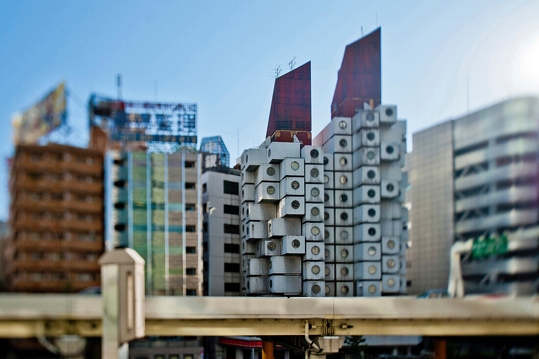The Nakagin Capsule Tower in the Ginza District, and an elevated rail or viaduct.