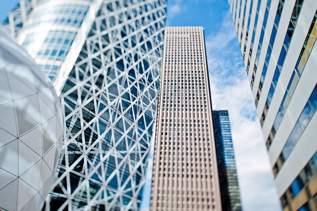 Skyscrapers in Tokyo's Shinjuku District. View up to the tall modern architectural landmarks from street level.