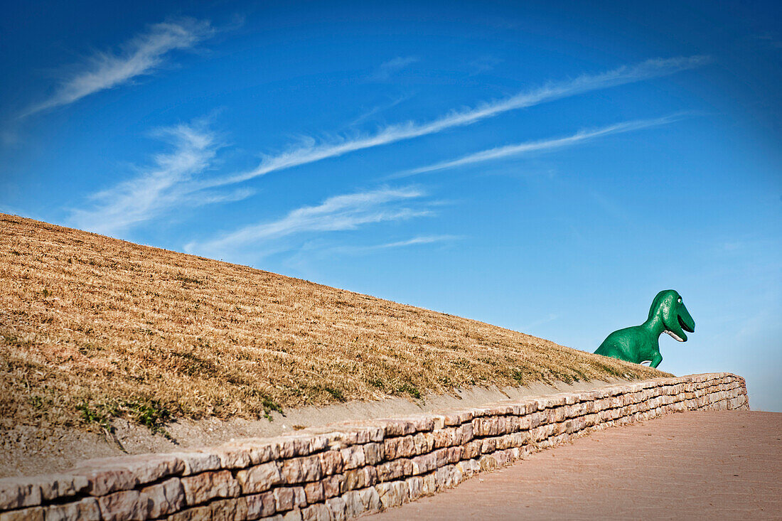 A green Tyrannosaurus Rex dinosaur statue in Dinosaur Park.