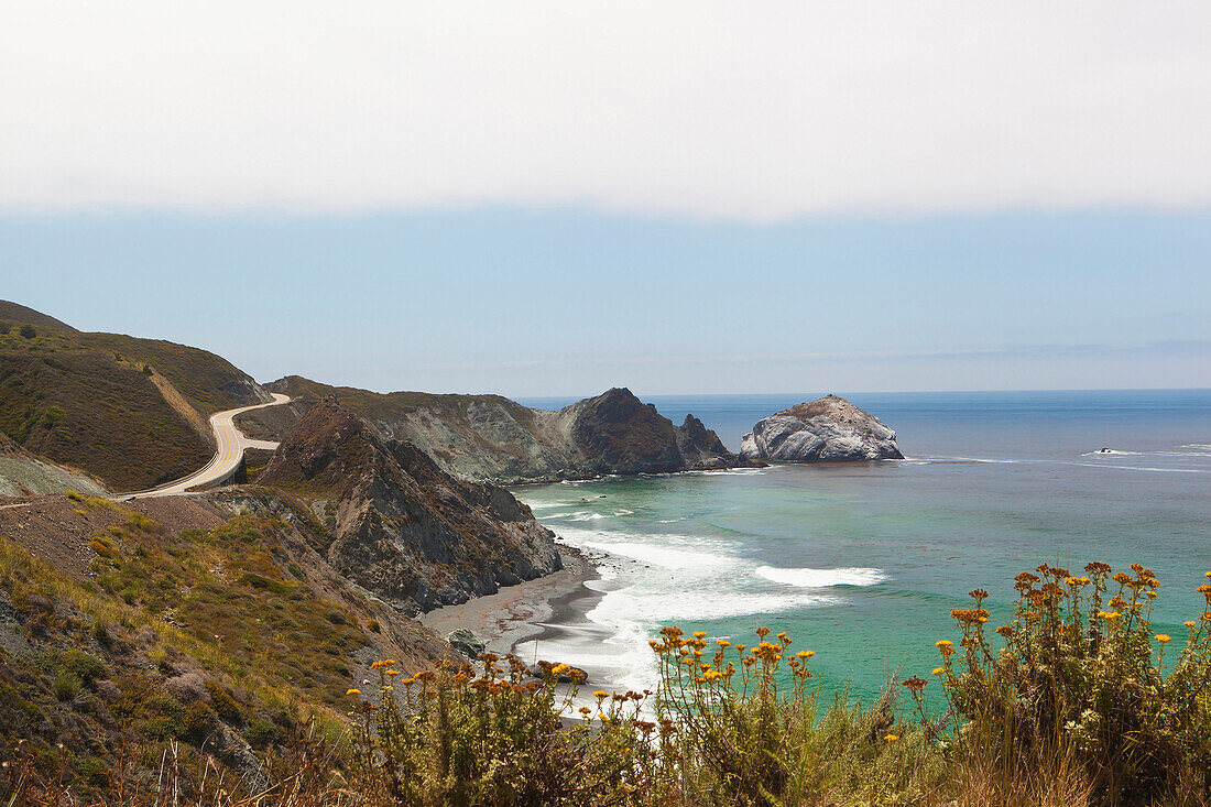 The Big Sur coastline on the Pacific Ocean with steep cliffs and sea stacks, rock arches and sandy coves along California State Highway 1