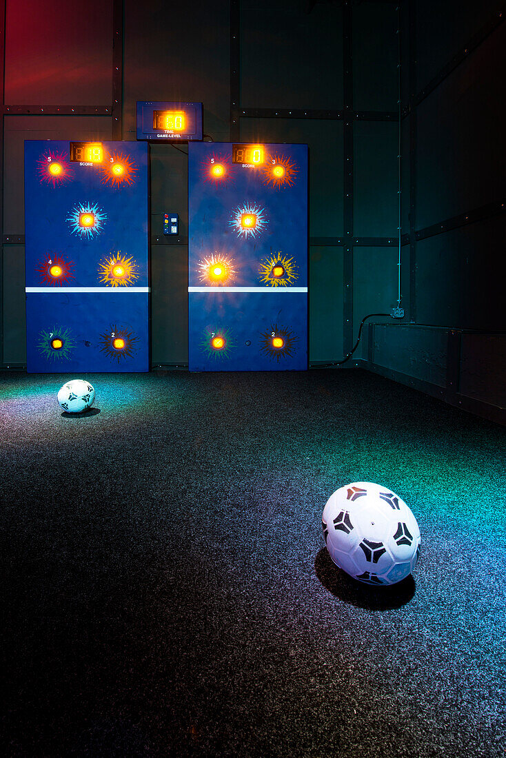 Soccer target game on one of the walls in a dimly lit active gaming center