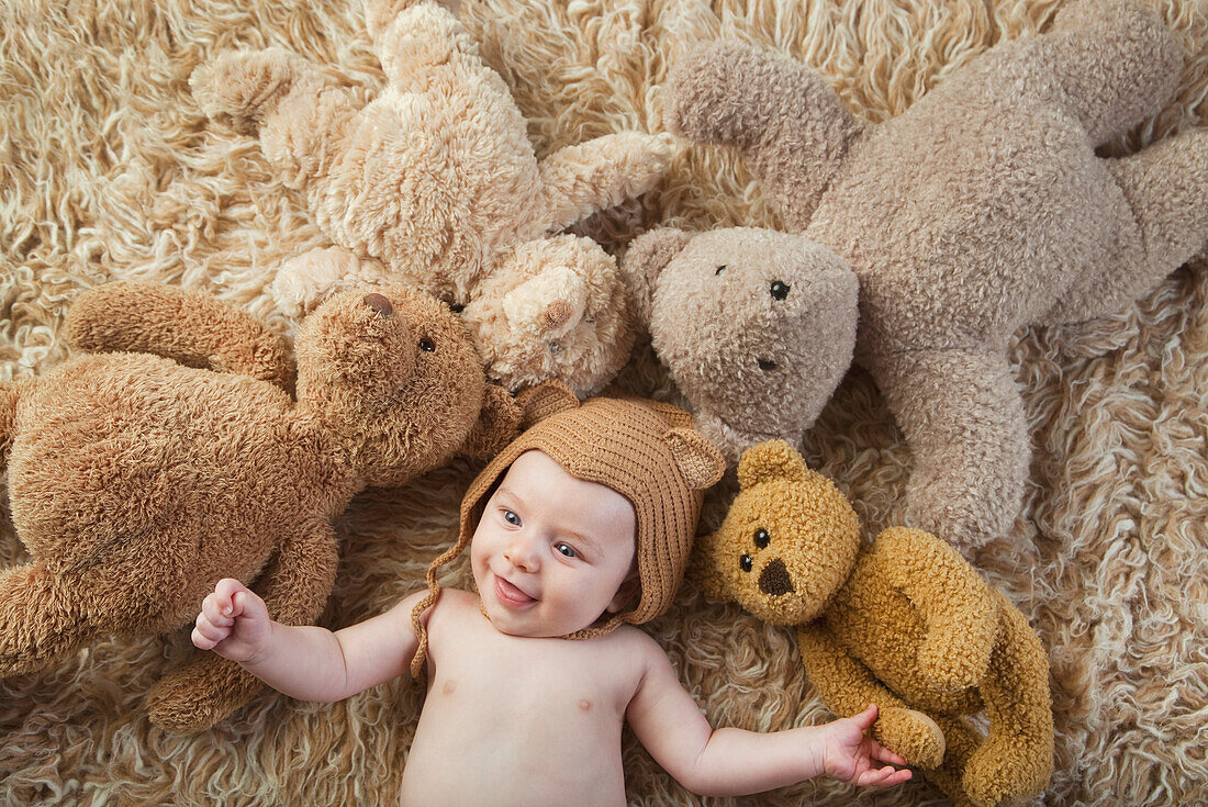 Baby Wearing Bear Cap Surrounded By Teddy Bears