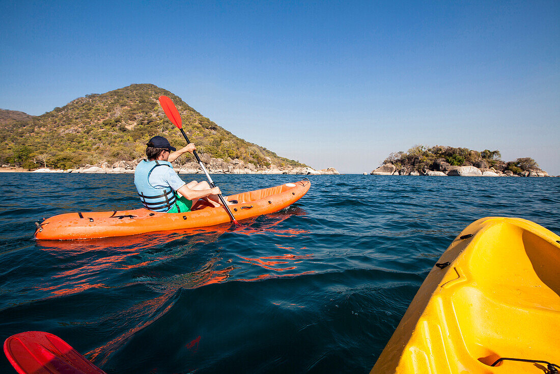 A man paddling in a canoe at Cape Maclear, Otters Point, Lake Malawi, Africa