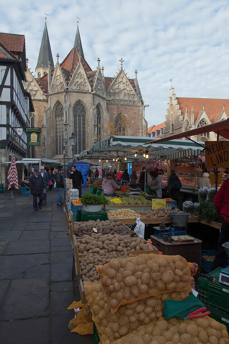Medieval market square in the old town with Gewandhaus, Rueninger Customs House, St Martini church and old town hall, market in the foreground selling vegetables and potatoes, Brunswick, Lower Saxony, Germany