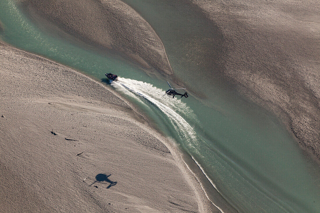 Luftaufnahme, Jetboot im Flachwasser eines Gebirgsflusses, verfolgt von Hubschrauber, bei Queenstown, Otago, Neuseeland