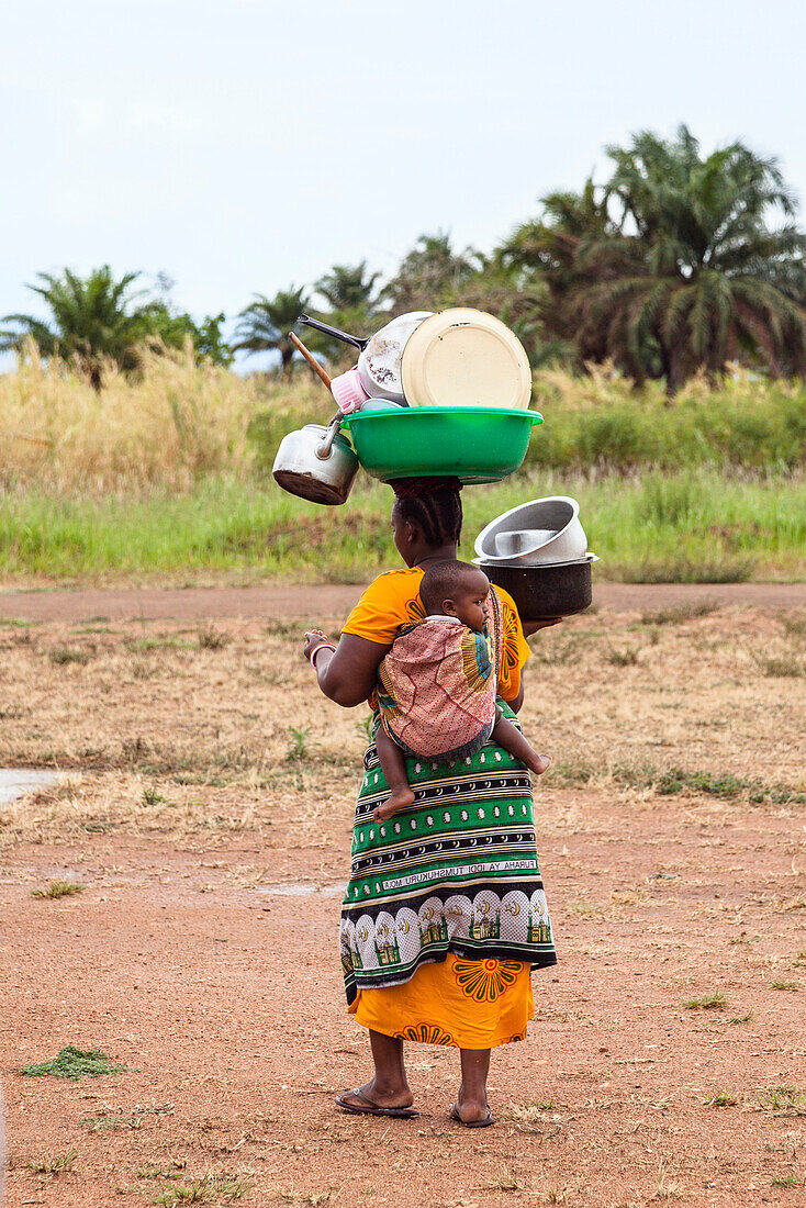 Local woman carrying baby and dishes to the lake to wash up, lake Tanganyika, Mahale Mountains National Park, Tanzania, East Africa, Africa