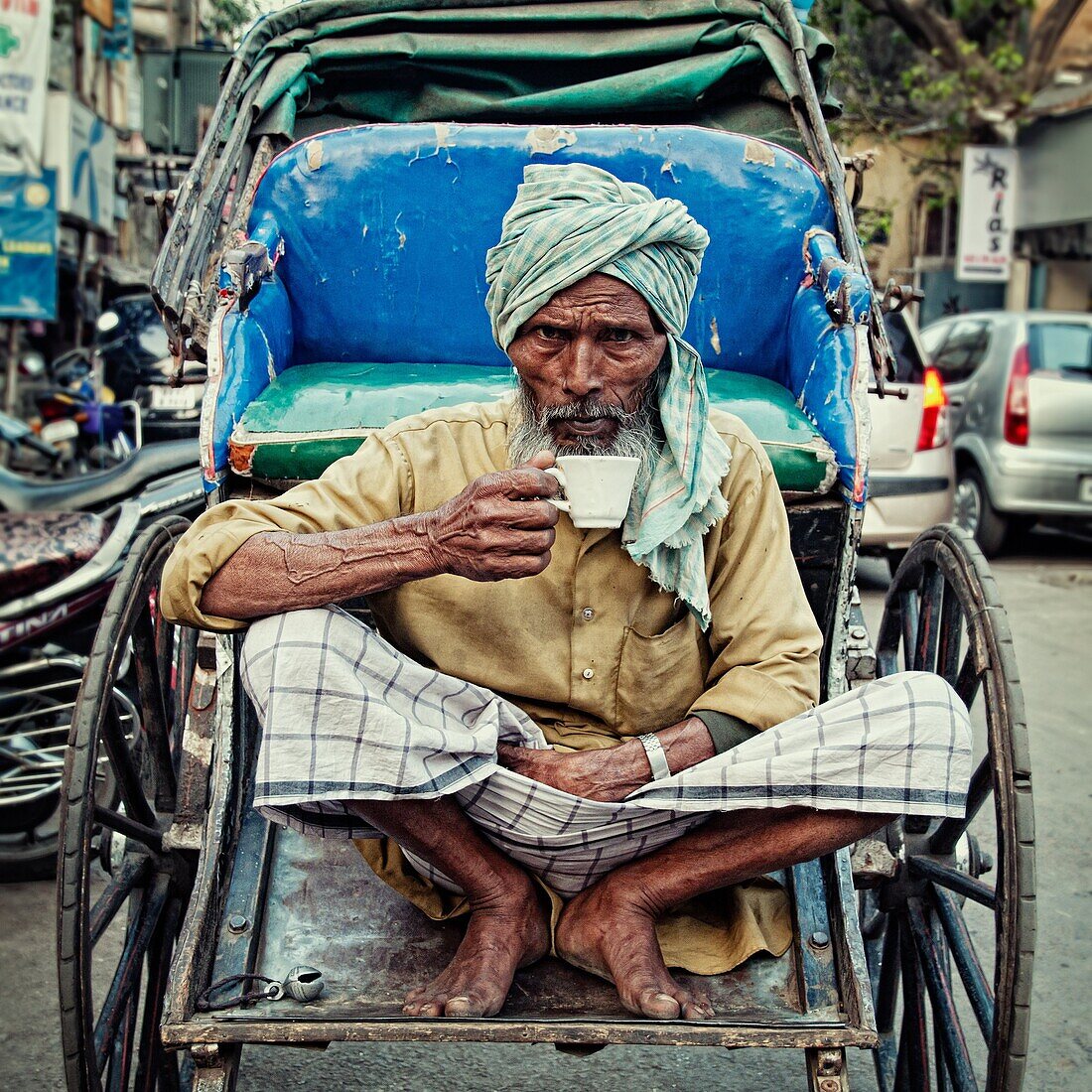 Rickshaw wallah taking a cup of indian tea on his rickshaw  Calcutta, India