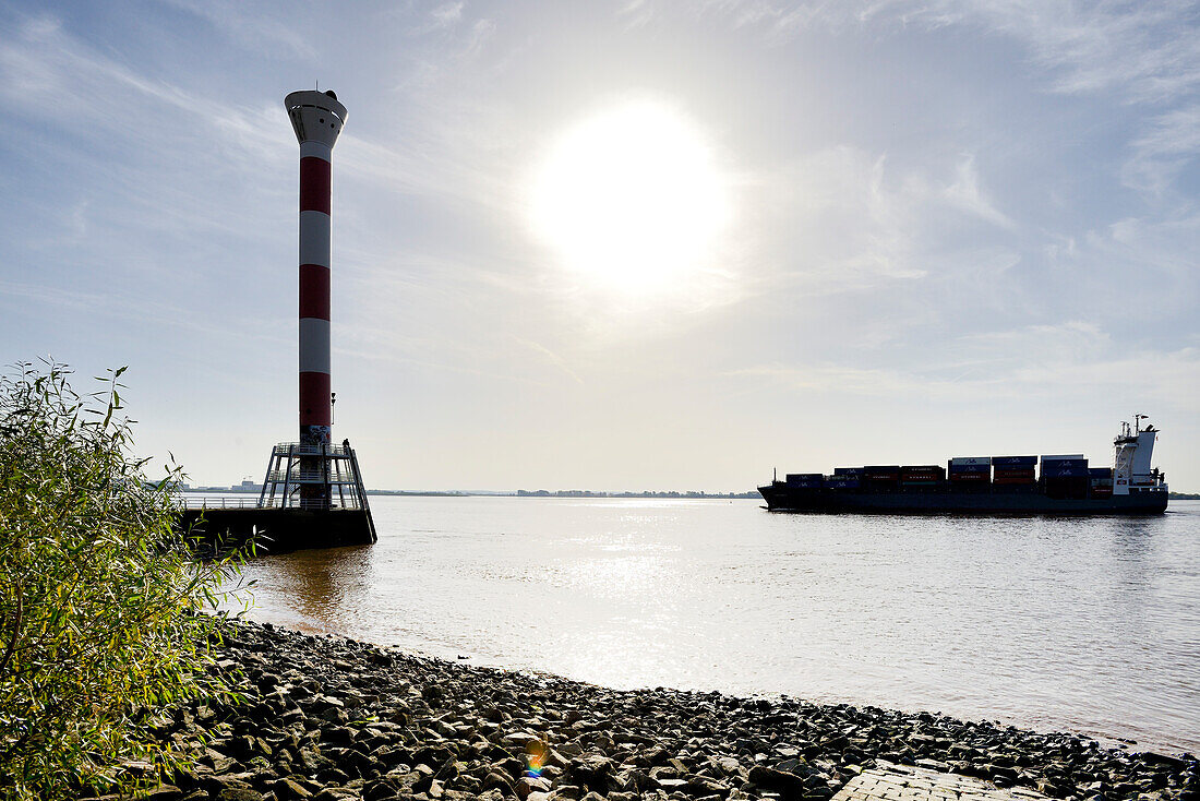 Blick auf die Elbe mit Leuchtturm und Containerschiff am Strand von Blankenese, Hamburg, Nordeutschland, Deutschland