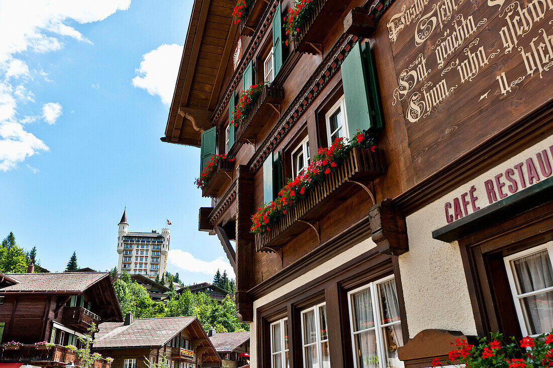 Blick auf Hotel Palace und typisches schweizer Haus in Gstaad, Berner Oberland, Schweiz, Europa