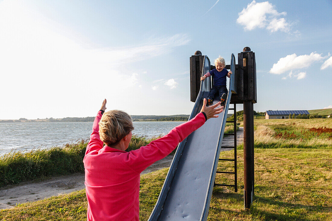 Mother and son (2 years) on a playground, Neu Reddevitz, Island of Ruegen, Mecklenburg-Western Pomerania, Germany