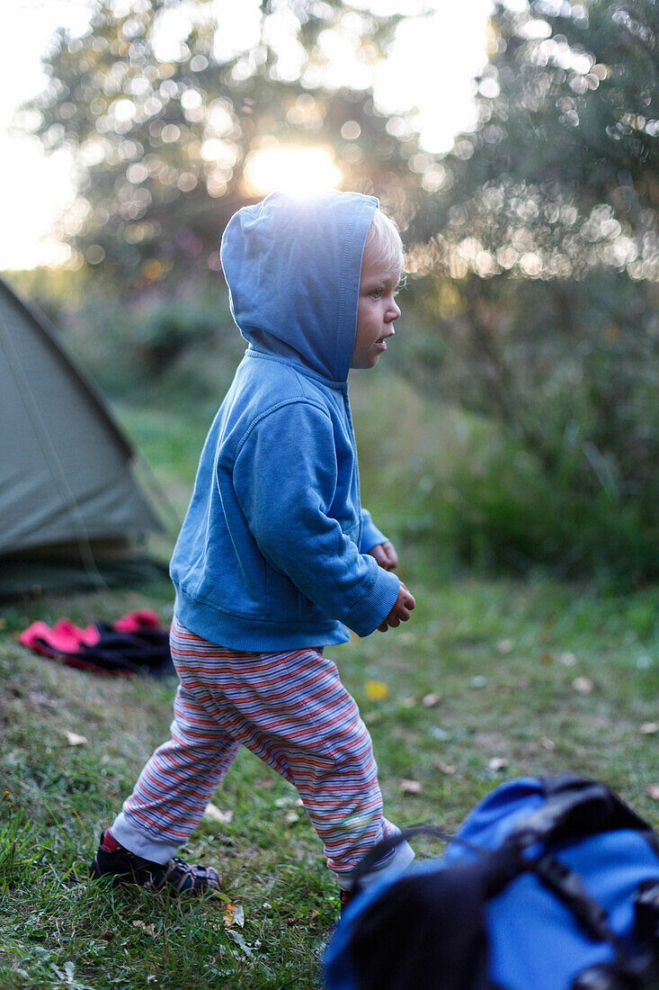 Boy (2 years) near a tent, Haide, Ummanz, Island of Ruegen, Mecklenburg-Western Pomerania, Germany
