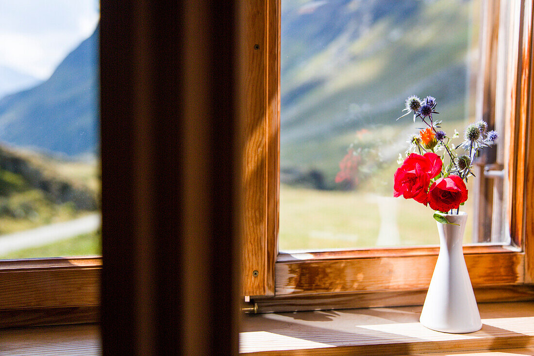 Morning light shines on a vase with mountain flowers inside the window of a hut, window view, Johannis Hut, Praegraten, Virgen Valley, Tirol, Austria