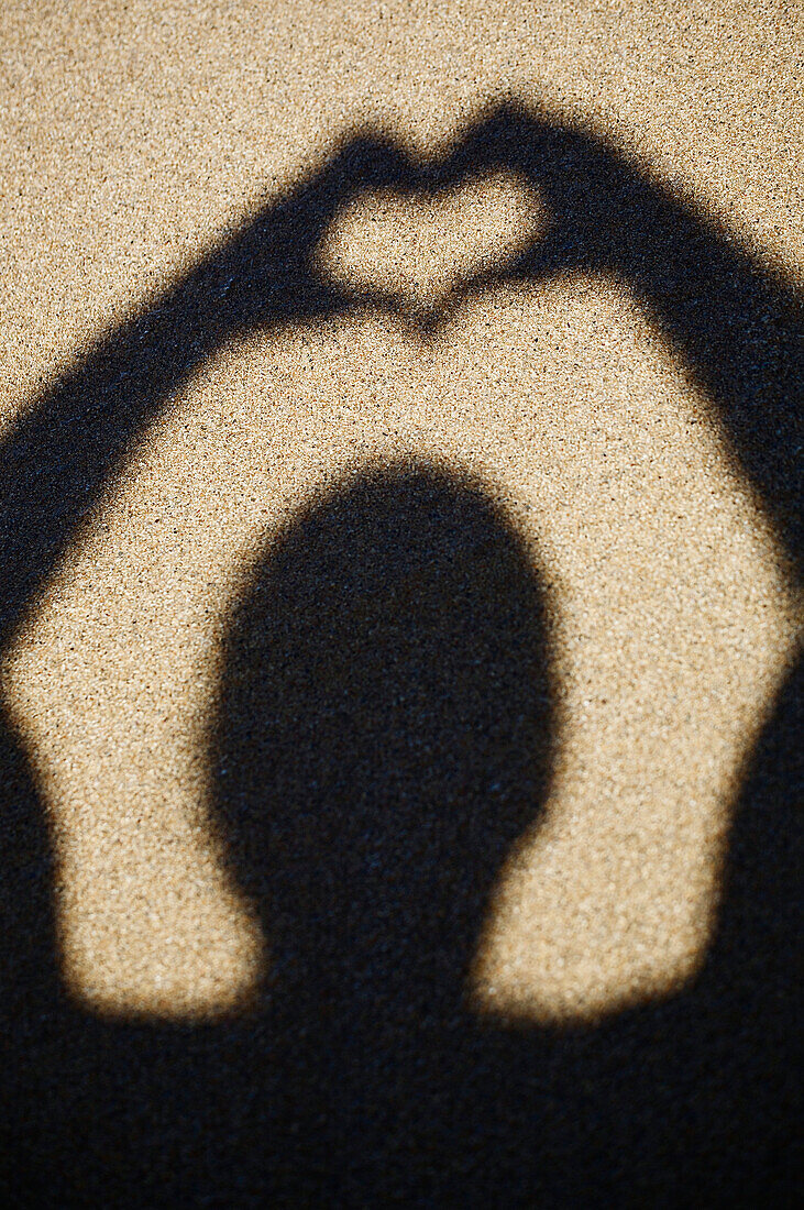 Hawaii, Kauai, Anini Beach, Shadow of a person in the sand making a heart.