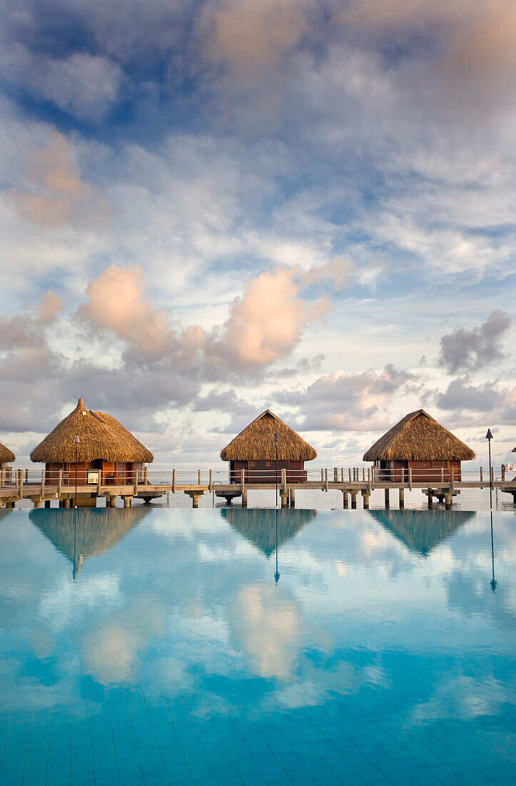 French Polynesia, Pearl Resort, Bungalows over beautiful turquoise ocean.