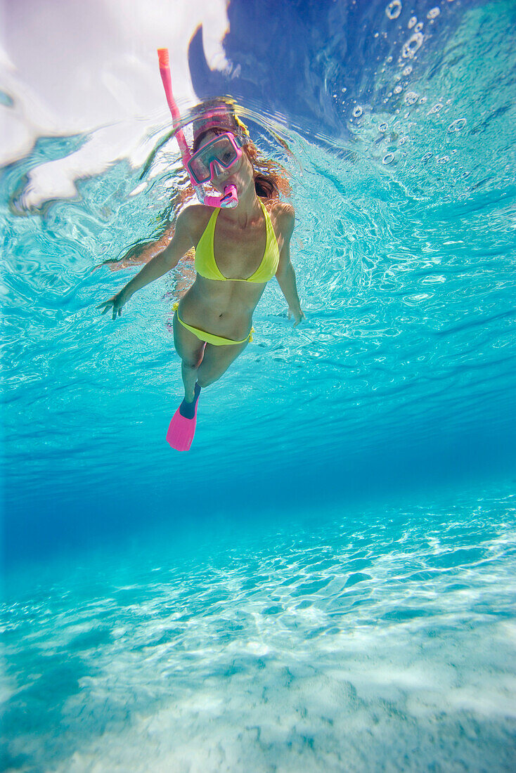 French Polynesia, Moorea, Woman free diving in turquoise ocean.