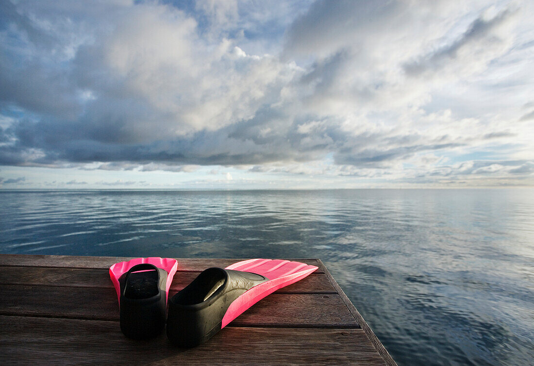 Hawaii, Pink fins on dock at sunset.
