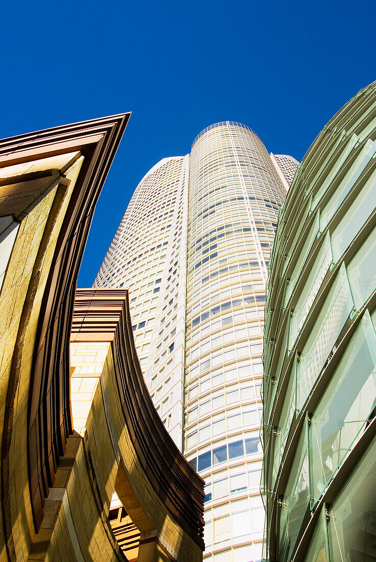 Japan, Tokyo, Roppongi Hills, upward view of Mori Tower framed by glass and stone of lower structures.