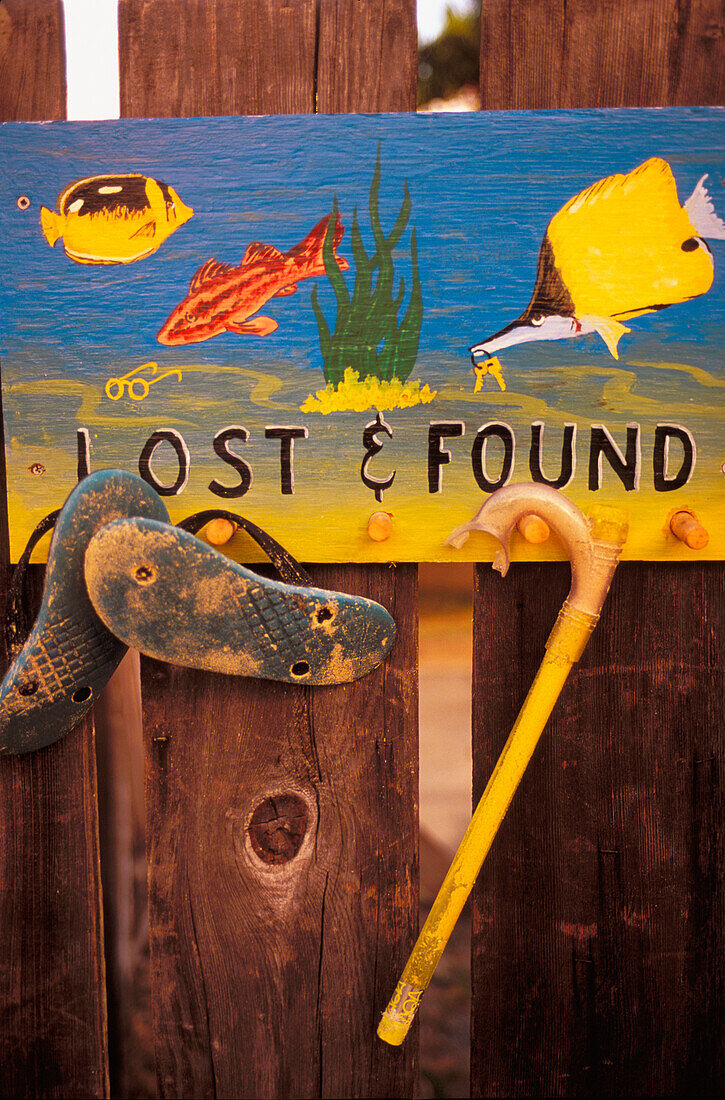 Hawaii, Oahu, Colorful hand painted lost and found sign on fence with snorkel and slippers
