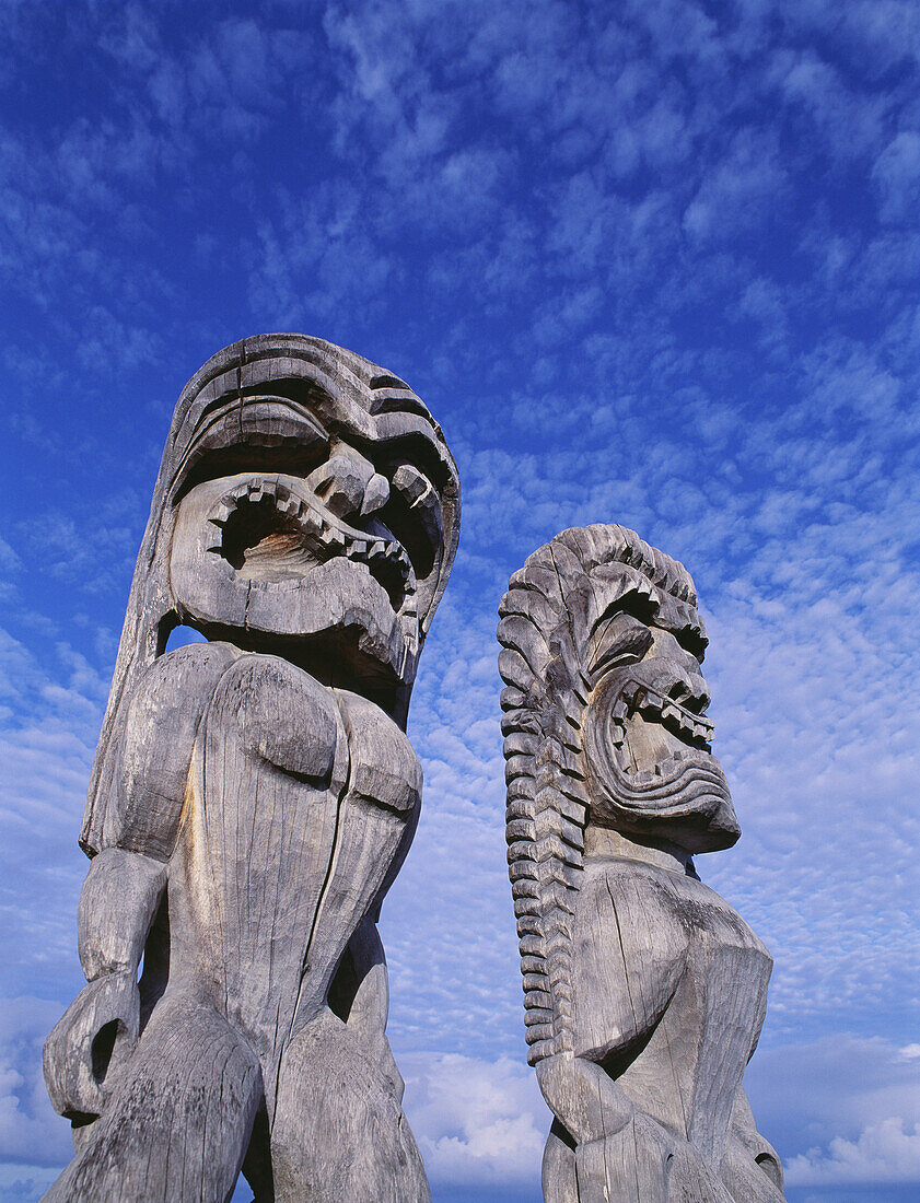 Hawaii, Big Island, Puuhonua O Honaunau, City of Refuge, Ki'i against bright blue sky and clouds.