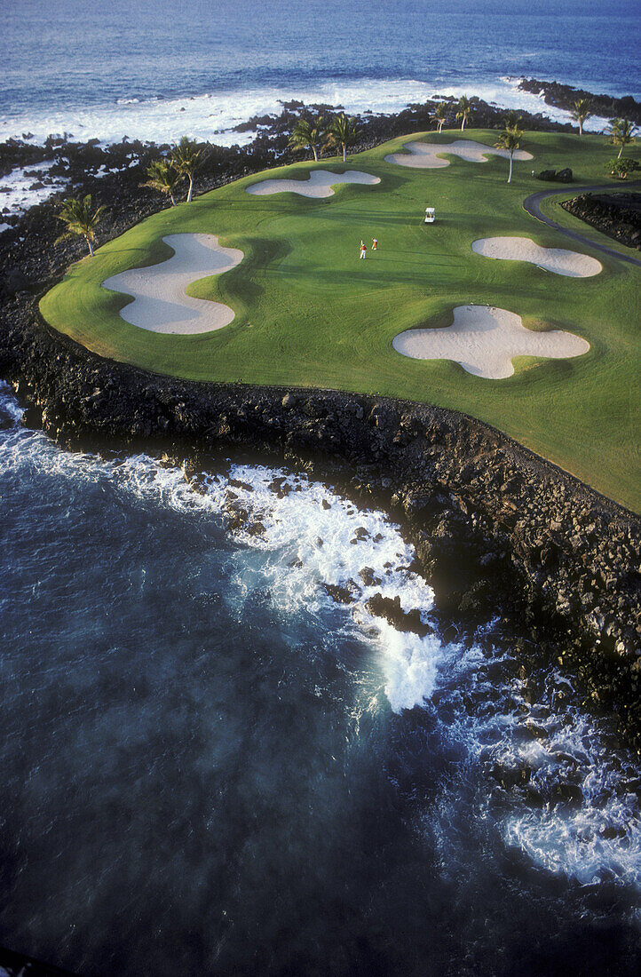 Hawaii, Big Island, Kohala Coast, Mauna Lani Resort, Francis I'i Brown Golf Course, couple golfing at 15th hole