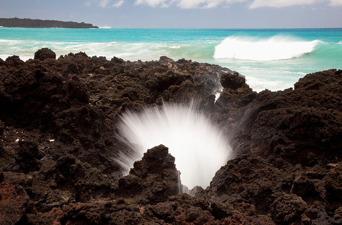 Hawaii, Maui, La Perouse Bay, A burst of water through a blowhole in some lava rocks.