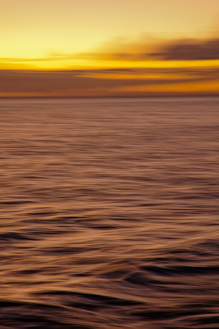 Hawaii, Maui, Ocean waves in motion and a vibrant tropical sunset.