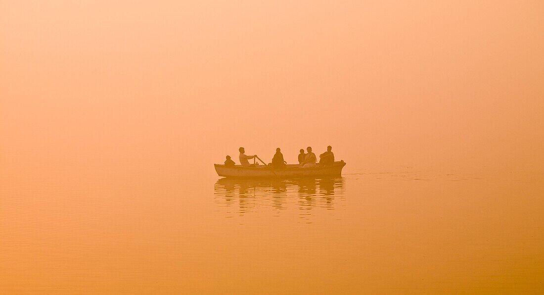 'The Ganges, Varanasi, India;Man Rowing Family In A Canoe On The River'