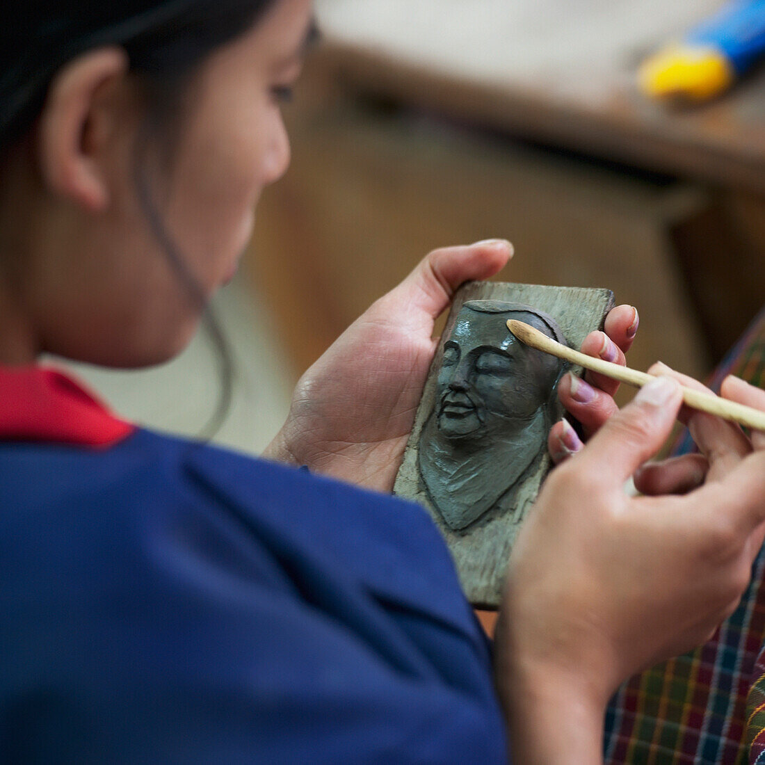 'A Woman Works On A Sculpture Of A Human Face; Thimphu Thimphu District Bhutan'