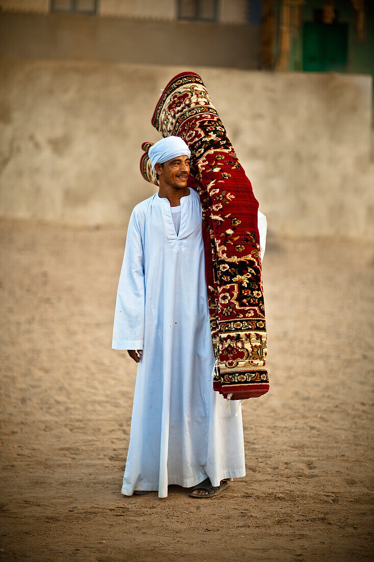 'A Muslim Man Carrying A Rolled Persian Rug; Nubia Egypt'