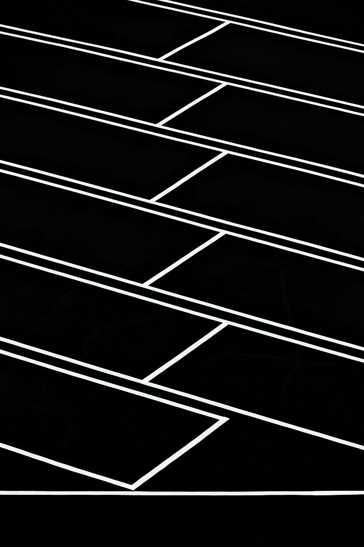 A car park, indoors parking lot, with a freshly resurfaced, black top surface, with newly painted white lines marking the parking bays., Los Angeles, California, USA. Parking Lot