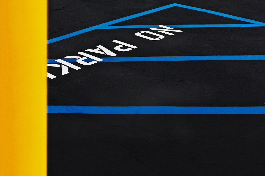 A car park, indoors parking lot, with a freshly resurfaced, black top surface, with newly painted blue lines on the ground. No Parking area., Los Angeles, California, USA. Parking Lot