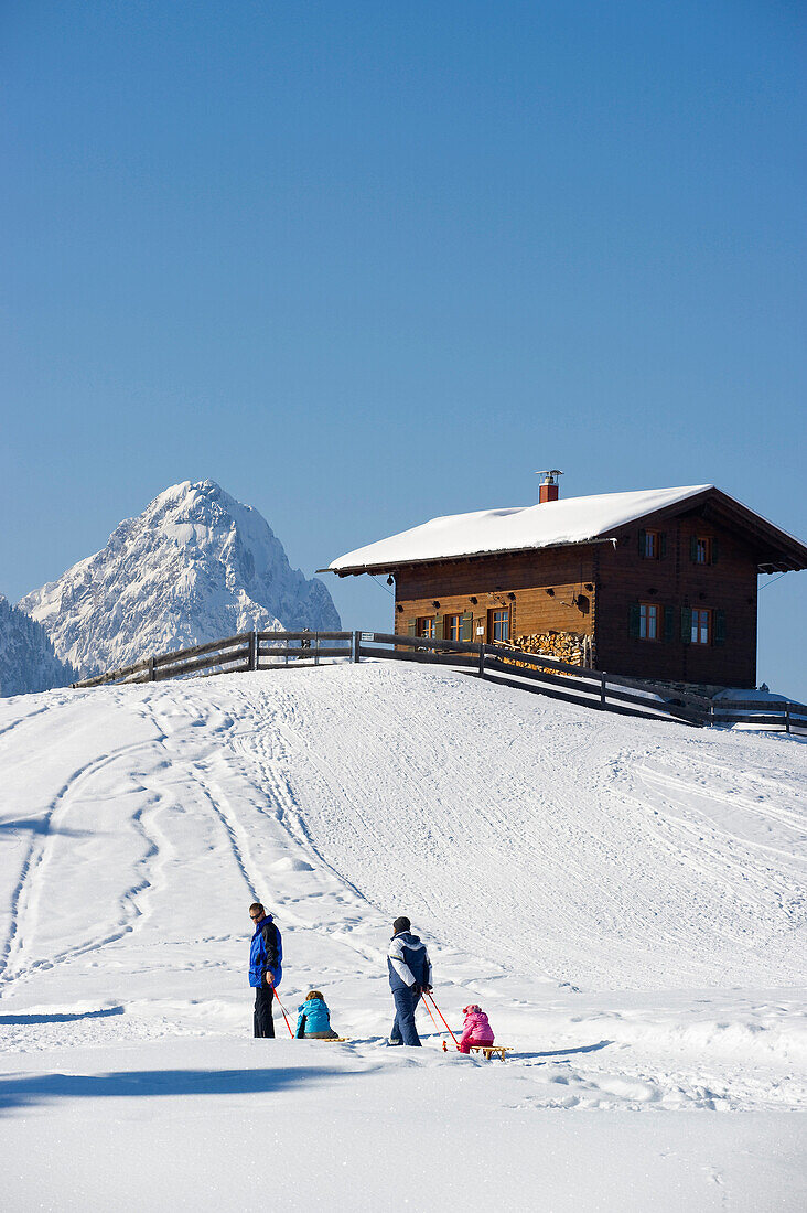 People sledging at Eckbauer, Alpspitze in the background, Garmisch-Partenkirchen, Bavaria, Germany