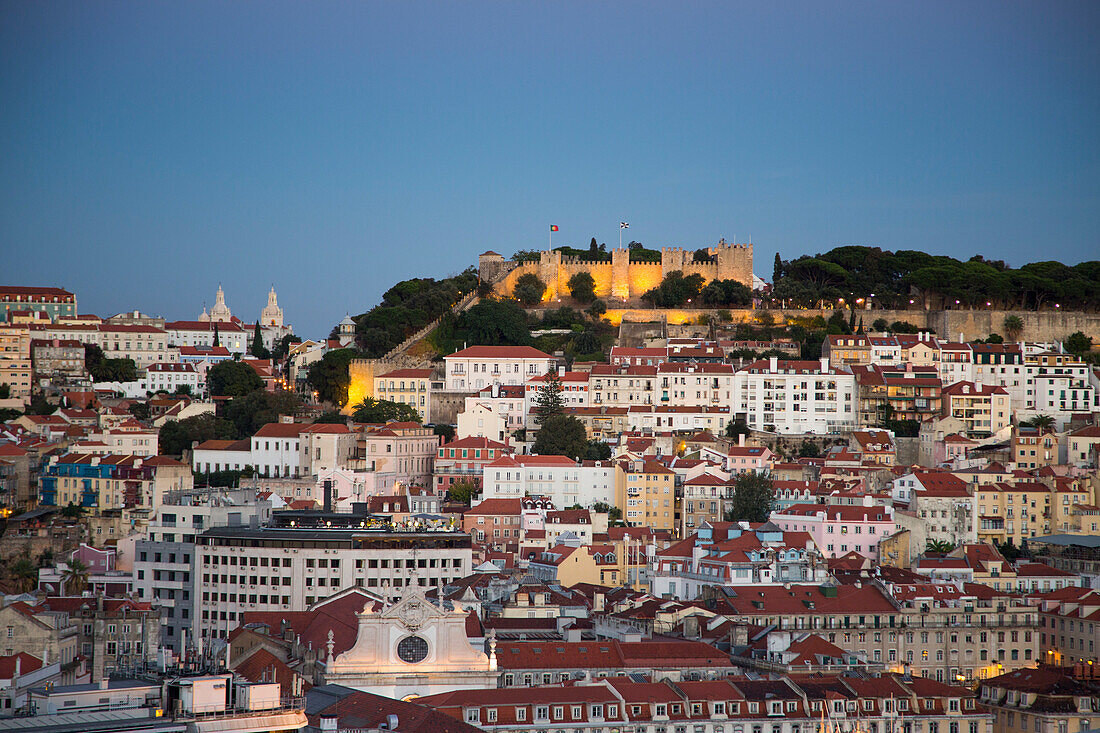Blick vom Aussichtspunkt Miradouro Sao Pedro de Alcantara im Stadtviertel Chiado auf die Baixa Unterstadt und das Castelo de San Jorge in der Abenddämmerung, Lissabon, Portugal
