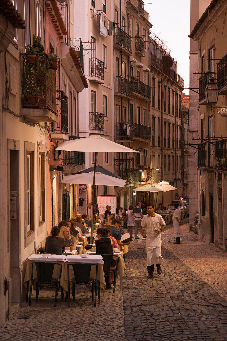 Menschen sitzen vor dem Alfaia Restaurant in der Bairro Alto Altstadt und genießen ihr Abendessen, Lissabon, Portugal