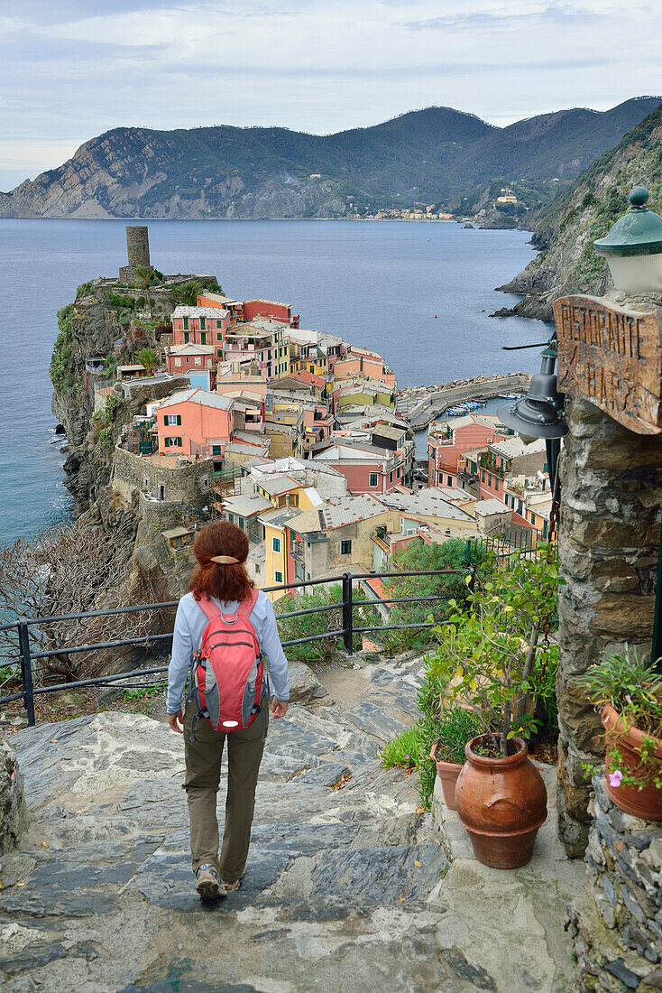 Frau geht auf Weg auf Vernazza zu, Meer im Hintergrund, Vernazza, Cinque Terre, Nationalpark Cinque Terre, UNESCO Weltkulturerbe Cinque Terre, Ligurien, Italien