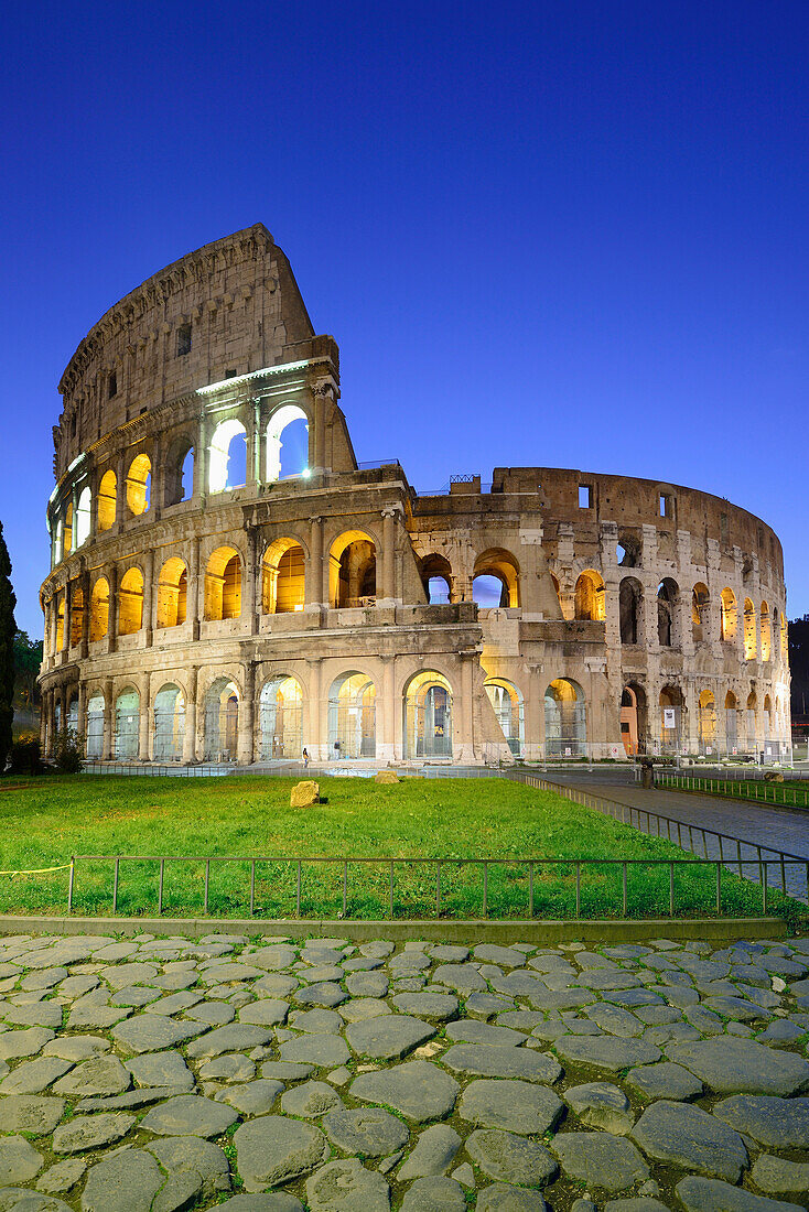 Colosseum, Kolosseum bei Nacht, beleuchtet, mit antikem Pflaster im Vordergrund, Rom, UNESCO Weltkulturerbe Rom, Latium, Lazio, Italien
