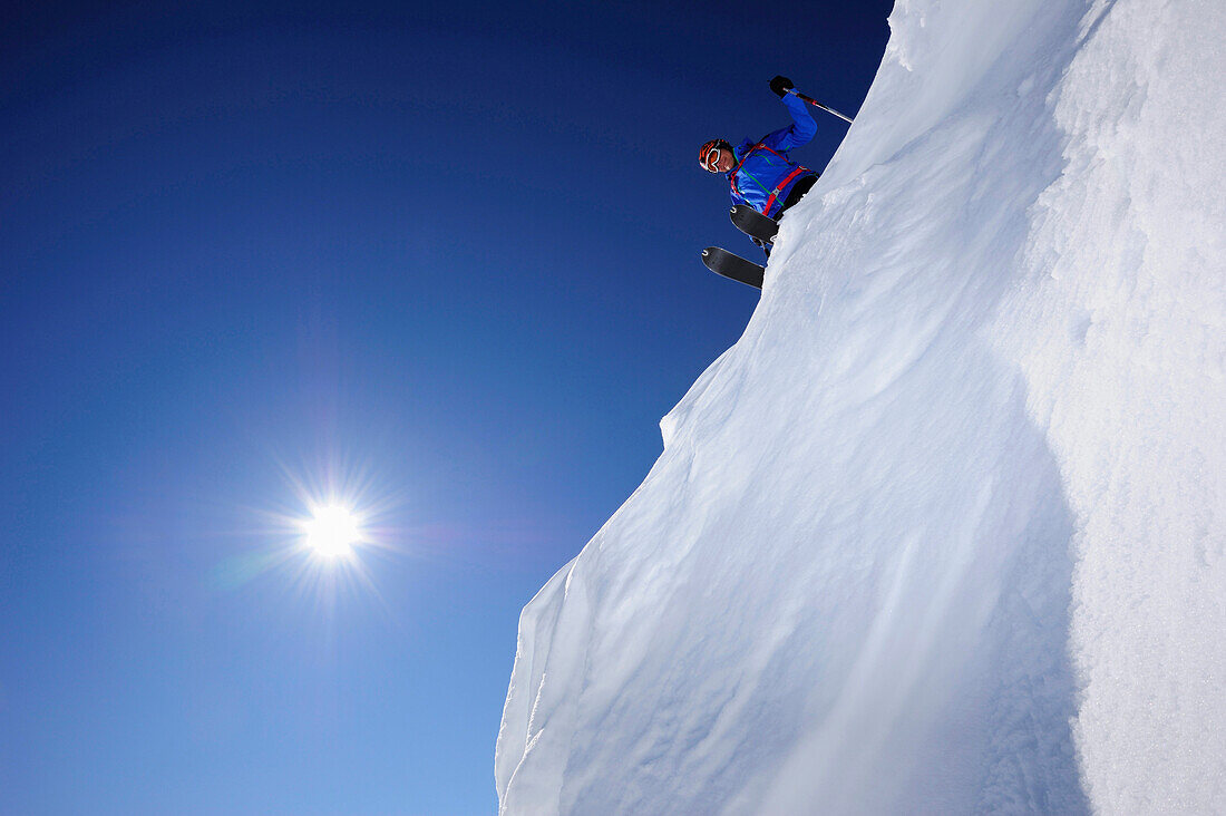 Skier on snow cornice preparing for downhill skiing, Grosser Rettenstein in background, Brechhorn, Kitzbuehel Alps, Tyrol, Austria