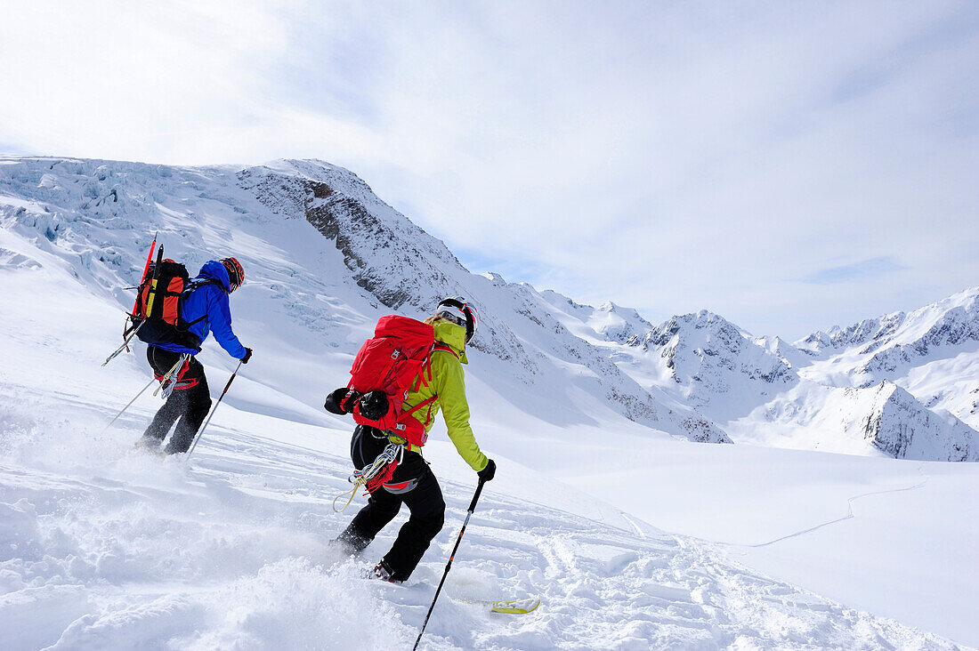 Two skiers downhill skiing from mount Wildspitzer on glacier, Oetztal Alps, Tyrol, Austria